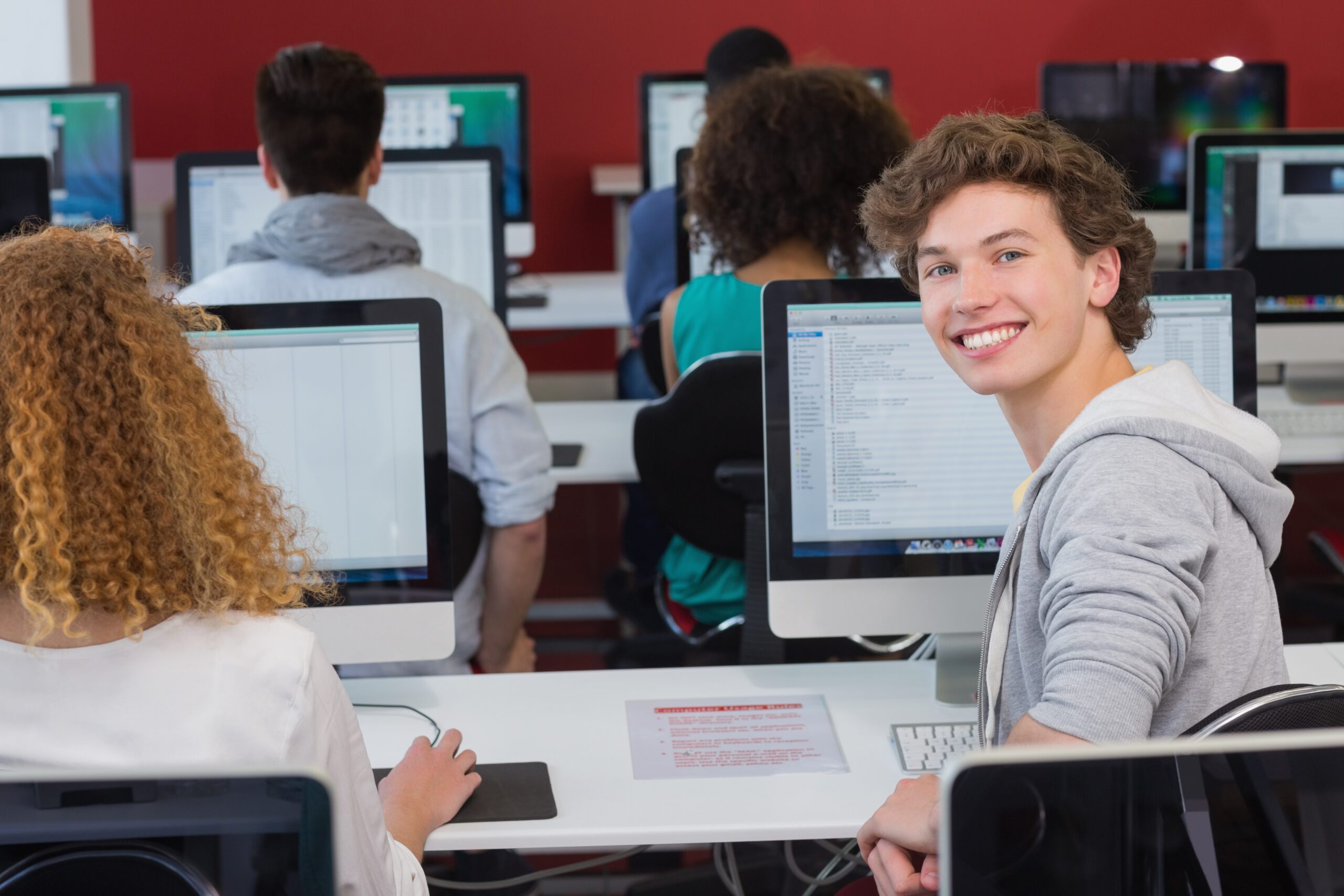 Student smiling at camera in computer class at the college
